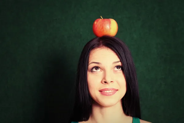 Giovane femmina con una mela sulla testa — Foto Stock