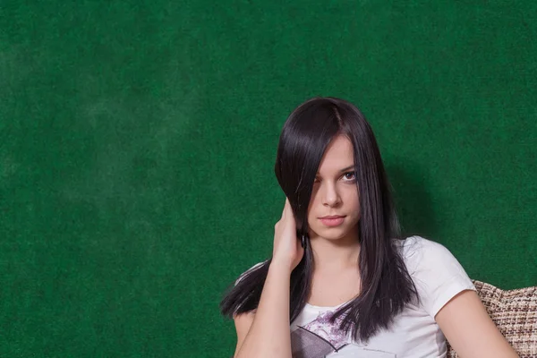 Ernstige brunette op groen — Stockfoto