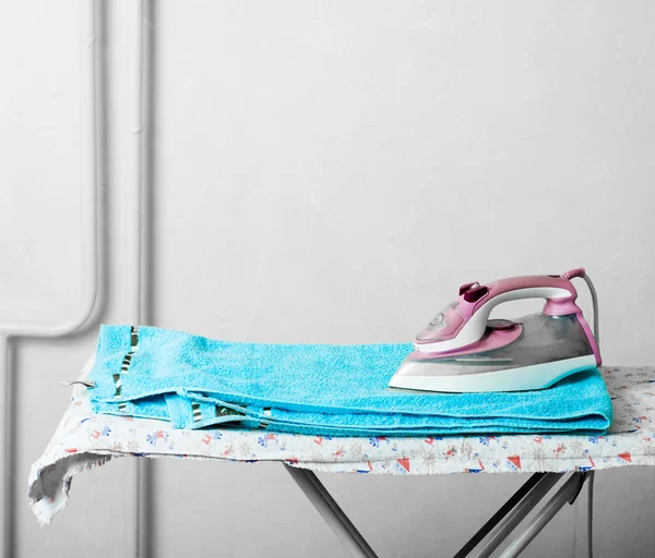 Σωρό πετσέτες και εξομάλυνση-σιδήρου στο τραπέζι — Φωτογραφία Αρχείου
