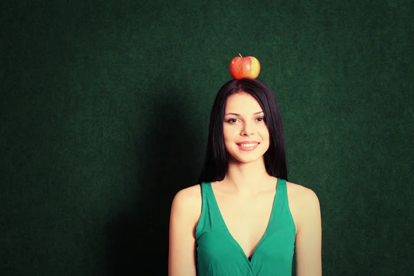 Young female with an apple on the her head — Stock Photo, Image