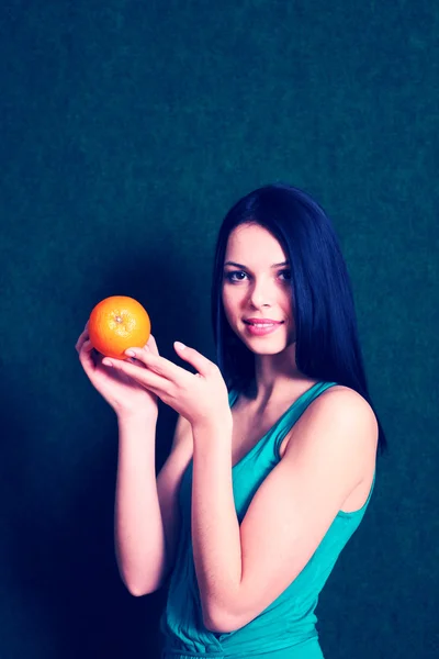 Fêmea com uma laranja nas mãos — Fotografia de Stock