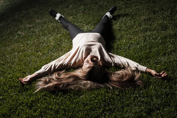Jonge aantrekkelijke blonde vrouw op gras — Stockfoto
