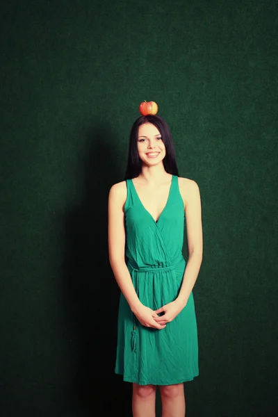 Młoda kobieta z jabłkiem na jej głowie — Zdjęcie stockowe