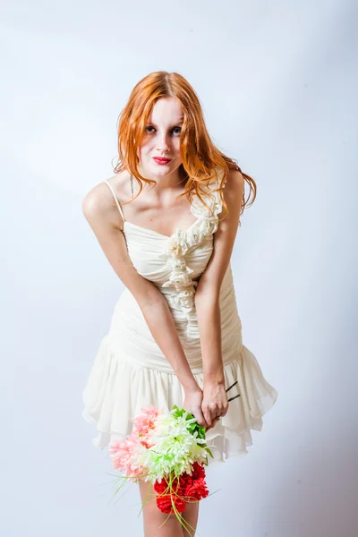 Redhead with bunch of flowers in studio on white — Stock Photo, Image