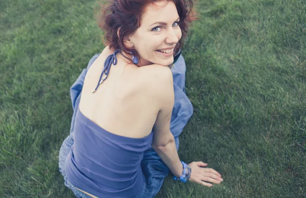 Souriant rousse fille sur herbe verte — Photo