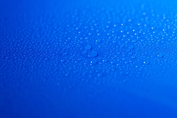 Gocce d'acqua su sfondo blu — Foto Stock