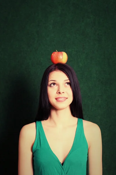 Young female with an apple on the her head — Stock Photo, Image