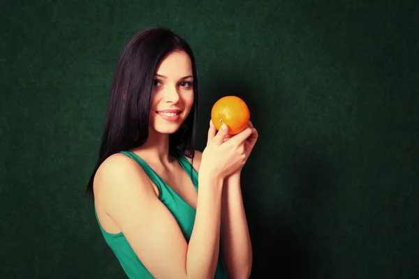 Vrouw met een oranje in haar handen — Stockfoto