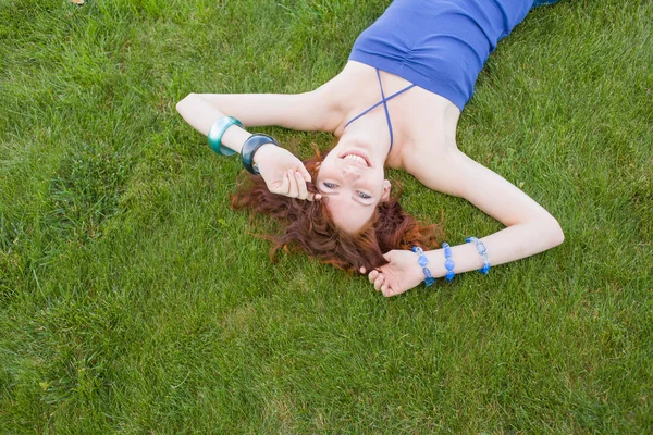 Sonriente pelirroja chica en verde hierba — Foto de Stock