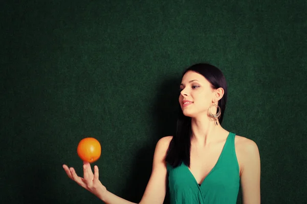 Vrouw met een oranje in haar handen — Stockfoto