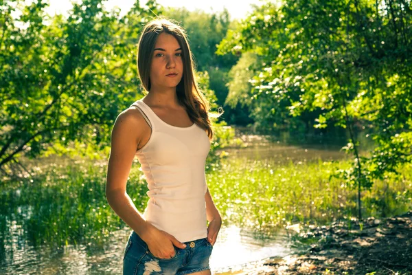 Hermosa mujer rubia joven en camiseta blanca y pantalones cortos de mezclilla riendo en voz alta (LOL) al aire libre — Foto de Stock