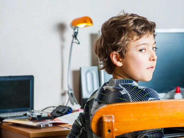 Vue latérale d'un petit garçon à table dans la chambre — Photo