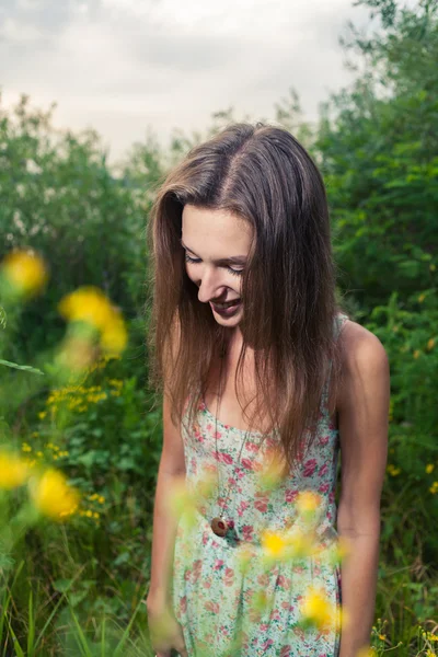 Mooie jonge vrouw in weide van bloemen. — Stockfoto