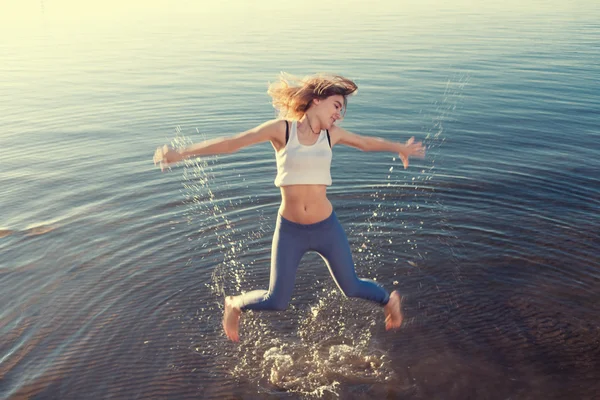 Young beautiful woman jumping in water — Stock Photo, Image