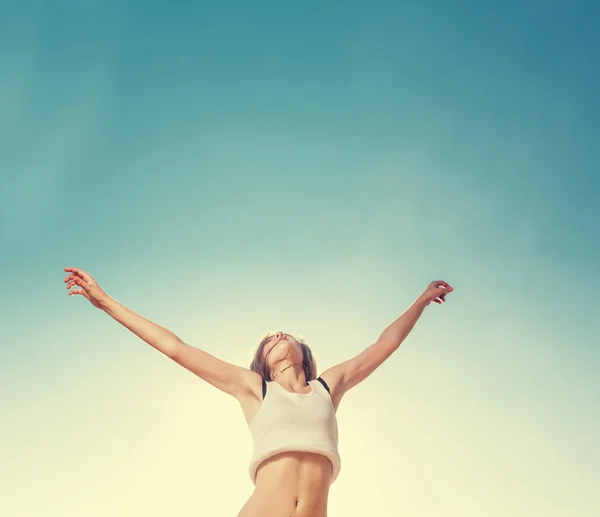 Ragazza bionda adolescente che salta felice con il cielo blu nella parte posteriore — Foto Stock