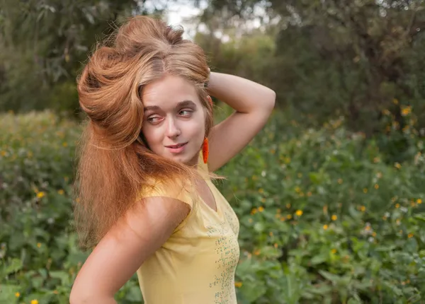 Menina bonito olhando para longe com a mão em seu cabelo — Fotografia de Stock