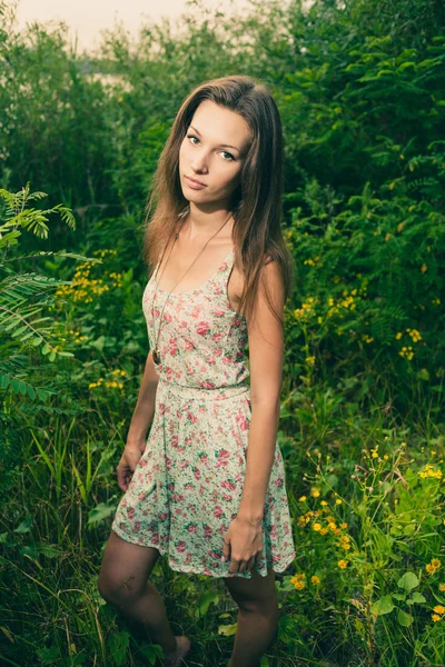 Vacker ung kvinna i ängen av blommor. — Stockfoto