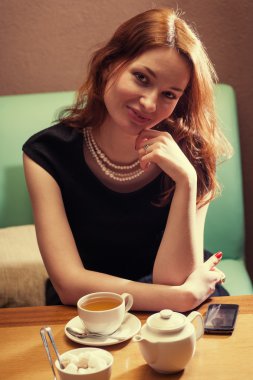 Kızıl saçlı kadın cafede oturan ön görünüm