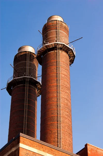 Chimenea-pila contra el cielo azul —  Fotos de Stock