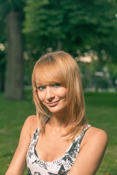 Молодая блондинка улыбается на улице — стоковое фото