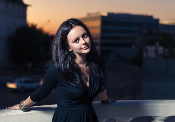 Brunette near balustrade in a evening — Stock Photo, Image