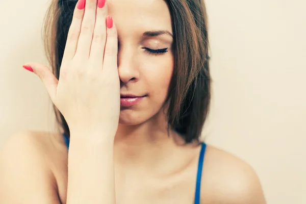 Donna che nasconde il suo occhio a mano — Foto Stock