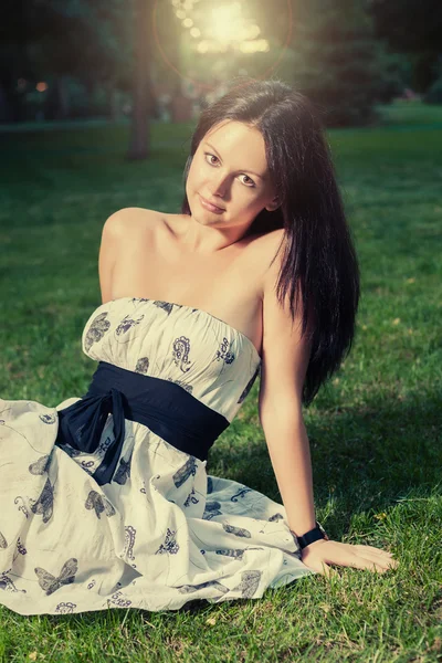 Brunette sitting on grass — Stock Photo, Image
