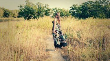 yüksek bir çim elbiseli kadın yürüyüş