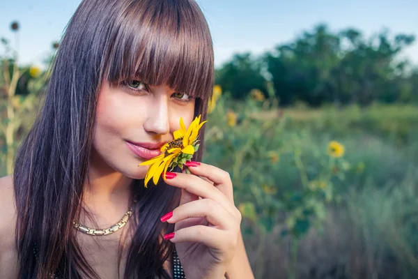 Frau riecht Sonnenblume — Stockfoto