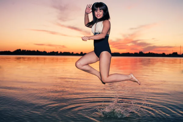 Retro zoek vrouw springen in water — Stockfoto