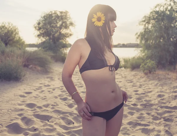 Beautiful woman in bikini standing on sandy beach — Stock Photo, Image