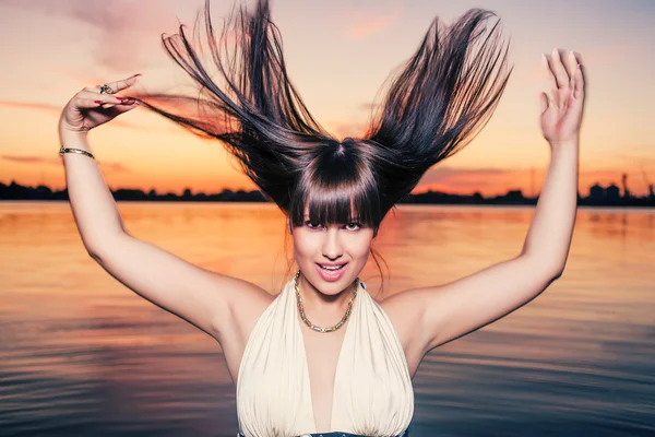 Dansen in water bij zonsondergang. vliegende haar — Stockfoto