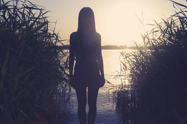Silhouette di una femmina contro l'acqua — Foto Stock