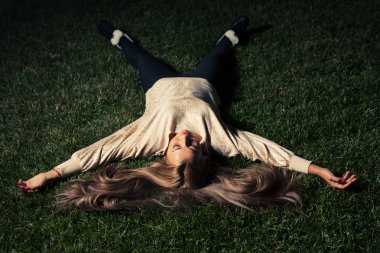 Yeşil çimenlerin üzerinde yatan kadın