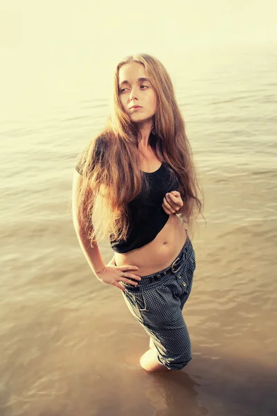 Blond haired woman standing in water in calm state — Stock Photo, Image