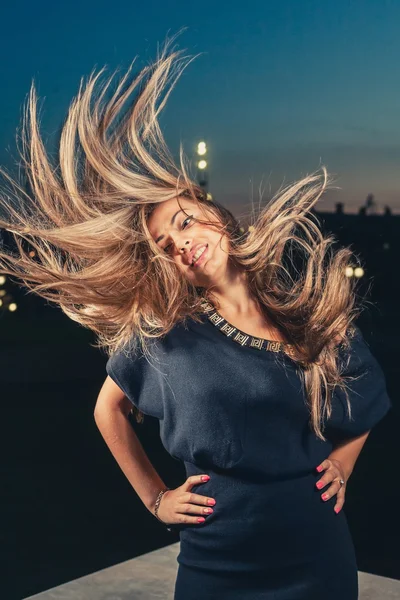 Cute woman posing with her hair flying in a air — Stock Photo, Image