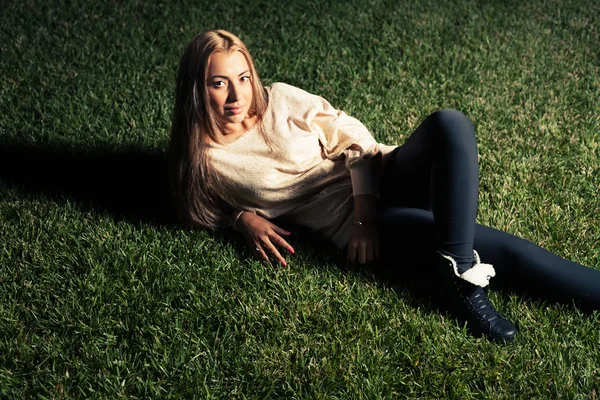 女性は緑の芝生の上に横たわるとカメラ目線 — ストック写真