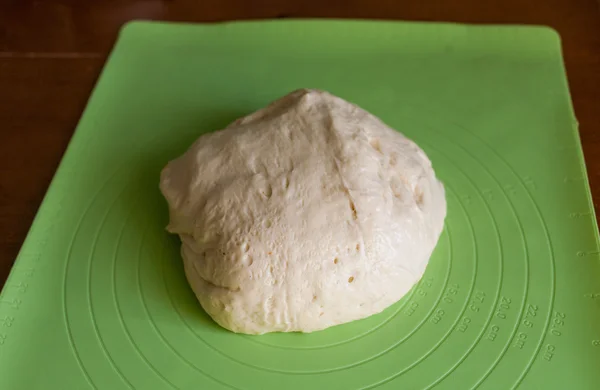 Тесто на зеленой тарелке на кухне — стоковое фото