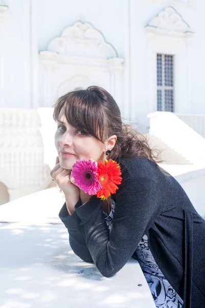 Brünette mit Blumen in ihren Händen — Stockfoto