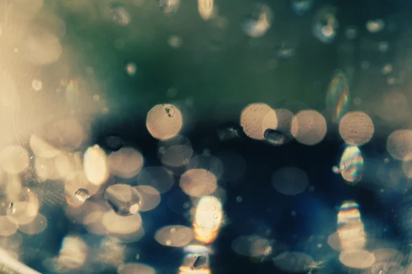 Gotas de lluvia desenfocadas en un fondo de pantalla de vidrio — Foto de Stock