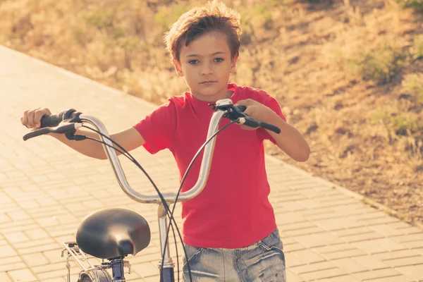 Stedelijke fietsen - kleine jongen en fiets in stadspark — Stockfoto