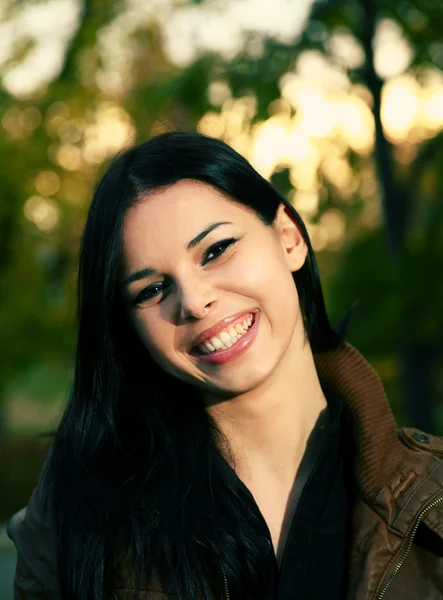 Jonge vrouw in het park glimlachen — Stockfoto