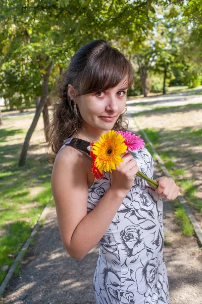 Esmer kızın ellerinde çiçeklerle — Stok fotoğraf