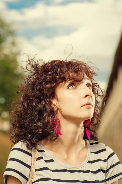 Curly haired women looking up. Summer shot of a pretty female ou — Stock Photo, Image