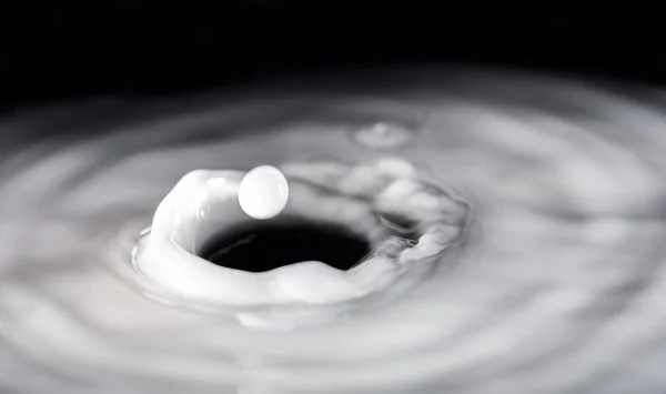 Круглые капли молока над кругами на жидкости — стоковое фото