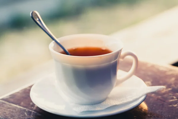 White cup of tea on a edge of wooden table — Stock Photo, Image