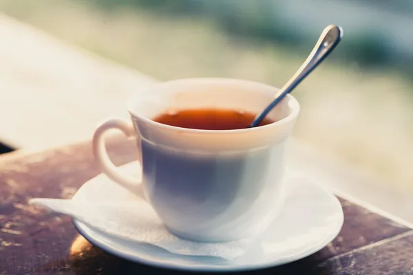 White cup of tea on a edge of wooden table — Stock Photo, Image