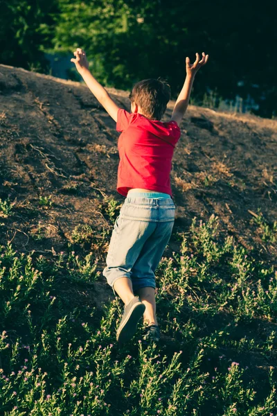 Small boy climb up slope — Stock Photo, Image