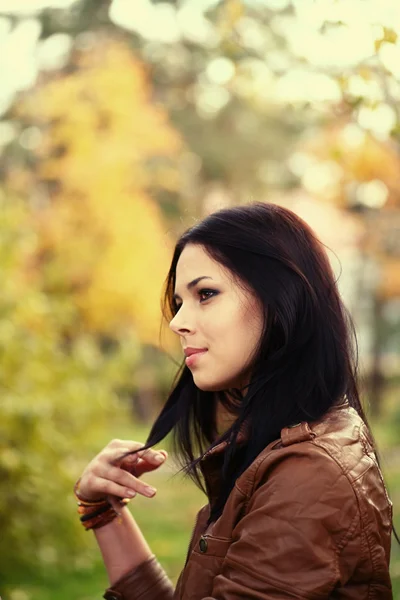 Portrait of a young woman in the park in profile. — Stock Photo, Image