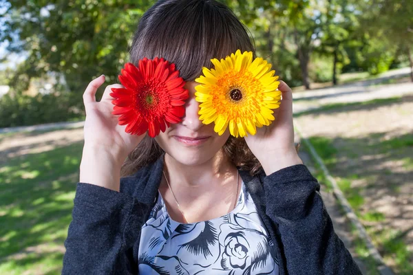 सुंदर लड़की Gerbera फूलों से अपनी आँखें छिपाती है — स्टॉक फ़ोटो, इमेज